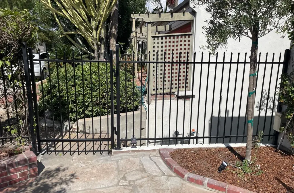 Residential metal fence installation in Los Angeles with black steel picket fencing for home security and curb appeal
